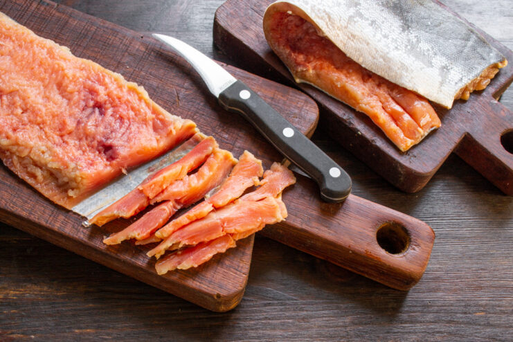 Chilling Cured Salmon for Easier Slicing A firm, cured pink salmon fillet on a cutting board, ready to be sliced.