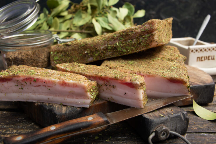 Pieces of dry-cured salo, seasoned with spices, ready to be served.