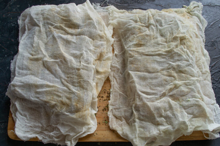 Wrapping the Salo in Cheesecloth for Aging A piece of spice-coated salo being wrapped tightly in white cheesecloth.