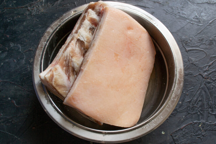 The Curing Process: Drawing Out Moisture Cured salo in a bowl after 3 days, showing the extracted liquid brine.