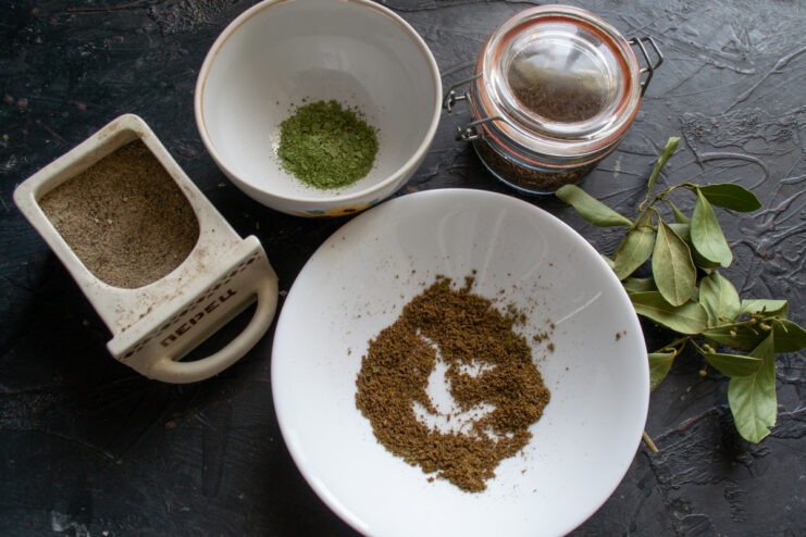 Preparing the Aromatic Spice Blend for Salo A coffee grinder filled with bay leaves and caraway seeds, ready for grinding.