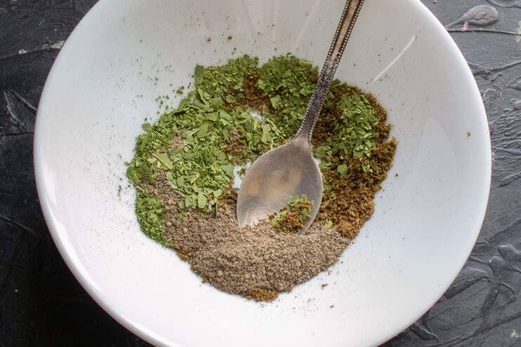 The Perfect Spice Mix for Authentic Salo A small bowl with a mixture of ground spices: caraway, bay leaf, and black pepper.