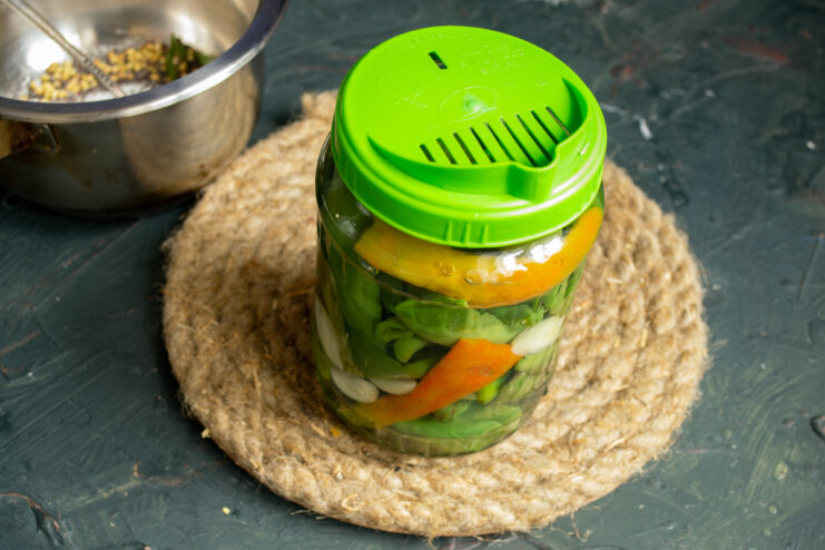 Measuring the liquid Using a perforated lid to drain water from a jar of packed chili peppers