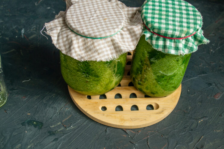 Starting the fermentation process Glass jars of cucumbers covered with breathable cloth secured by rubber bands