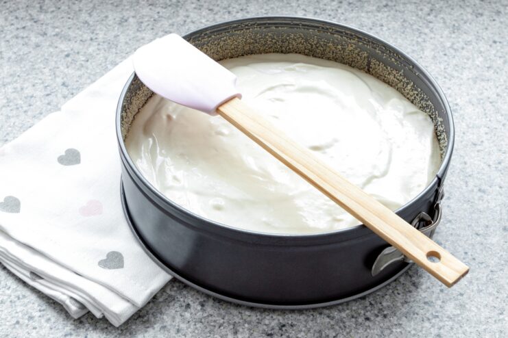 Sponge Cake Batter in a Baking Pan Round baking pan filled with freshly whipped sponge cake batter and a silicone spatula.