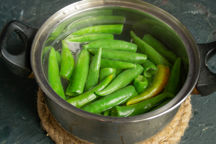 Blanching the peppers Blanching green chili peppers in a pot of boiling water