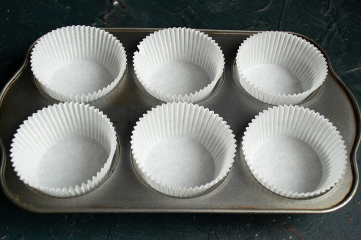 Preparing Muffin Tins Paper liners placed inside a metal muffin tin