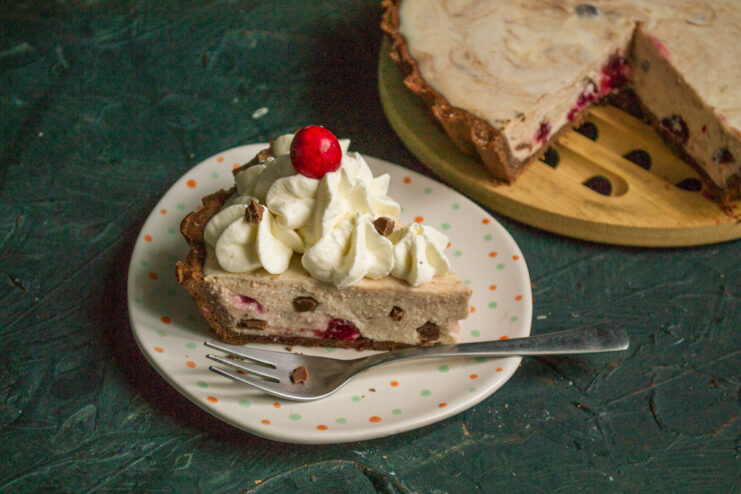 Garnishing the Finished Dessert Decorating a slice of cheesecake with freshly whipped cream and chocolate shavings
