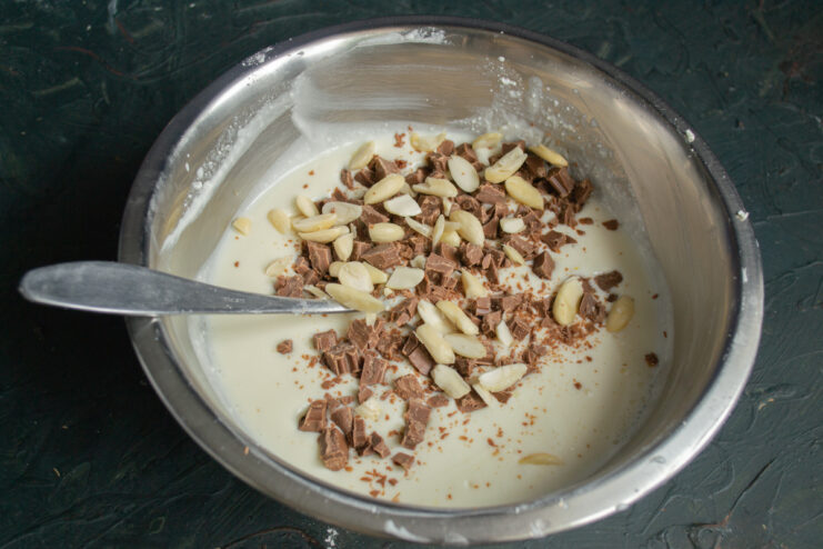 Adding Nuts to the Filling Stirring chopped peanuts into the creamy cheesecake filling