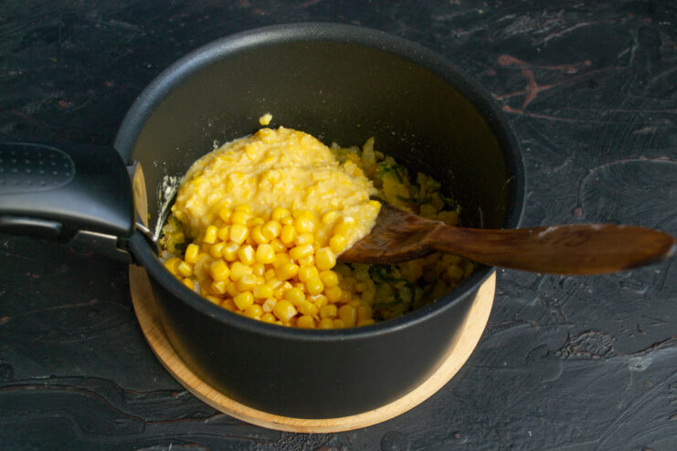 Combining the Vegetable Base and Corn Adding whole kernels and pureed corn to the pot