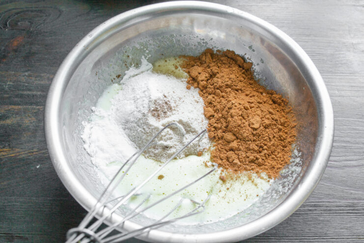Adding Dry Ingredients Adding cocoa powder, rice flour, and spices to the egg mixture