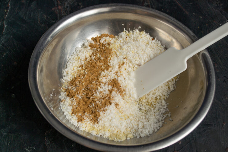 Sprinkling ground cinnamon into the nut and coconut mixture