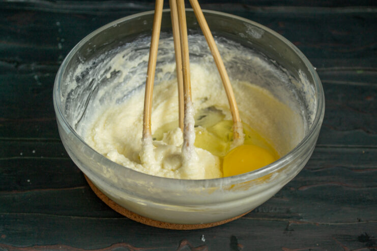 Adding egg to the dough Adding a chicken egg to the margarine mixture