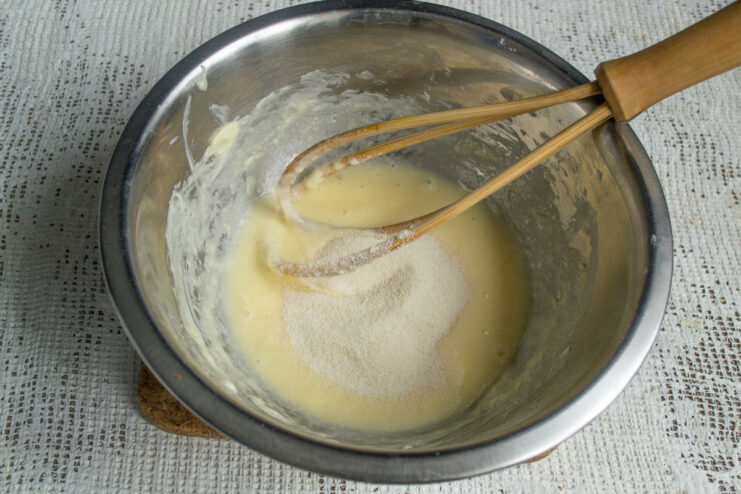 Adding semolina to the dough Pouring semolina into the cookie dough mixture