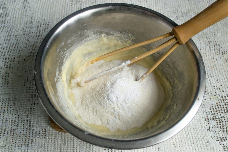 Kneading the shortbread dough Adding flour and baking powder to a mixing bowl