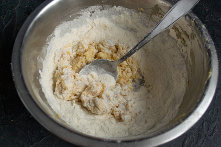 Folding in Flour Adding all-purpose flour to the wet mixture in a bowl