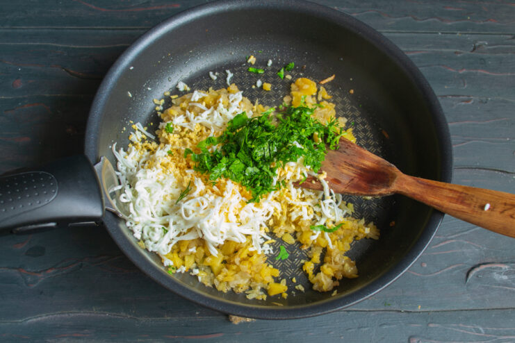 Stirring fresh parsley and dill into the skillet