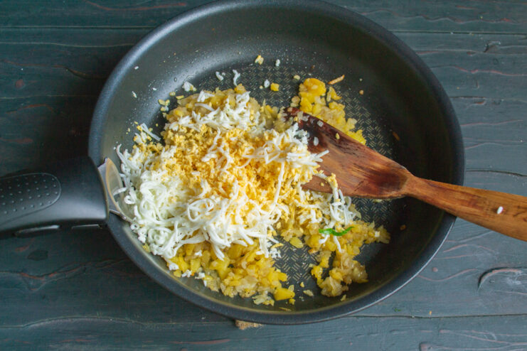 Adding grated boiled eggs to the turnip filling