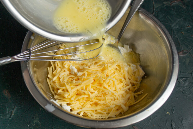 Adding eggs to the filling Pouring beaten eggs into the cheese mixture in a bowl