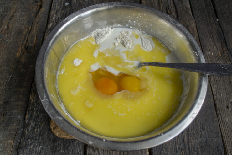 Adding Eggs to the Batter Cracking eggs into the mixing bowl with cake batter