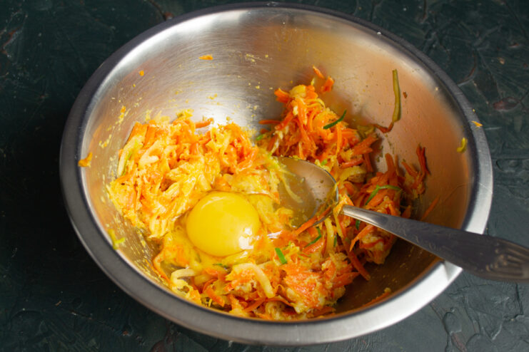 Cracking an egg into the vegetable and bread mixture