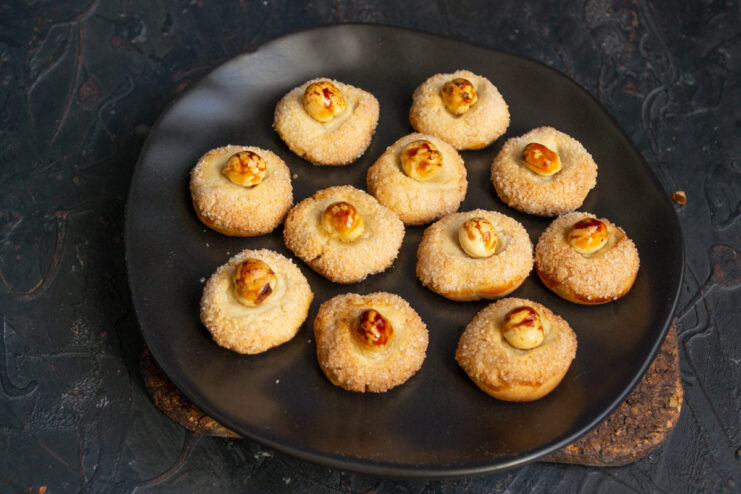 Serving thumbprint cookies Homemade hazelnut thumbprint cookies served on a black platter.