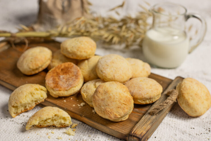 Homemade Pyshki cookies served on a wooden board next to a pitcher of milk