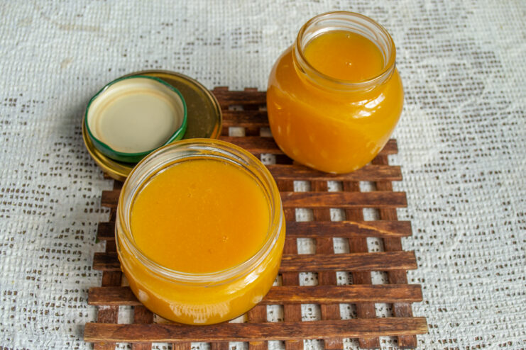 Finished marmalade in jars Two glass jars filled with thick, set apricot marmalade.