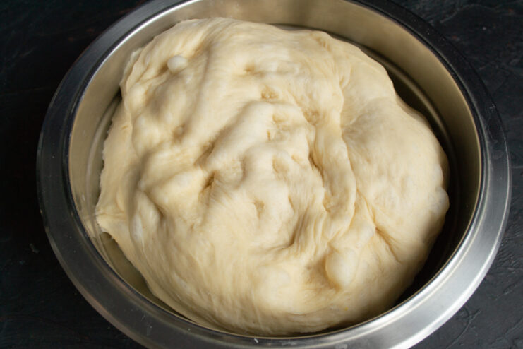 Kneaded dough Smooth and elastic yeast dough resting in a metal mixing bowl