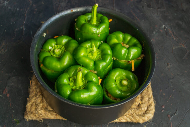Covering the stuffed peppers Stuffed bell peppers covered with their stem tops in a pot