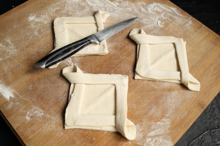 Crossing the cut dough strips to form raised borders for the tart