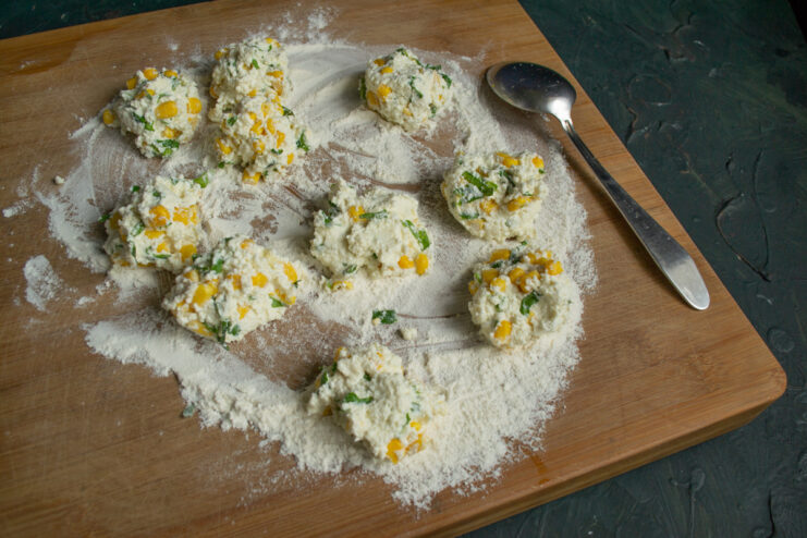 Portioning the dough into equal pieces Forming raw pancake patties on a flour-dusted cutting board