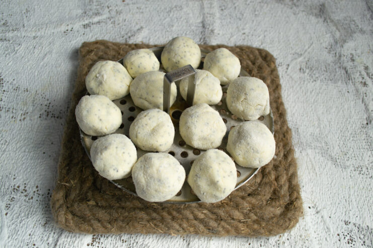 Preparing for steaming Raw dumplings placed on an oiled steamer rack