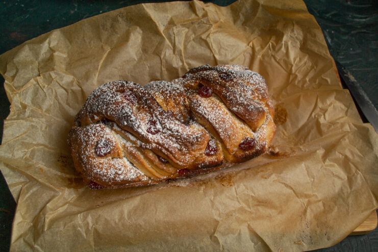 Finishing touches Finished Polish babka on parchment paper dusted with powdered sugar