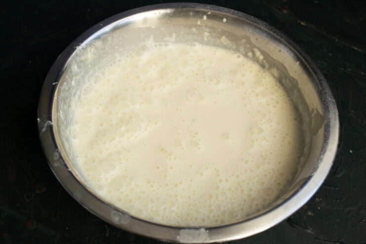 Finished crepe batter with air bubbles in a mixing bowl.