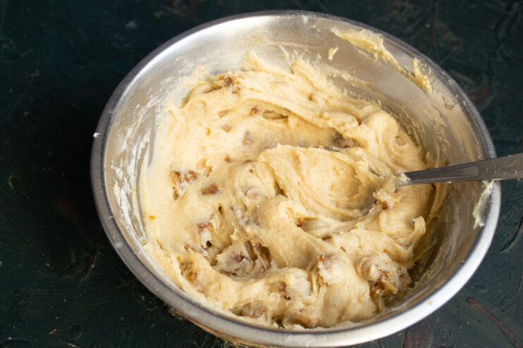Finished muffin batter Thick, smooth muffin batter dotted with chopped figs in a metal bowl.