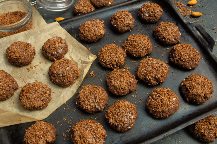 Baked eggless chocolate cookies topped with almond crumbs and chocolate sprinkles
