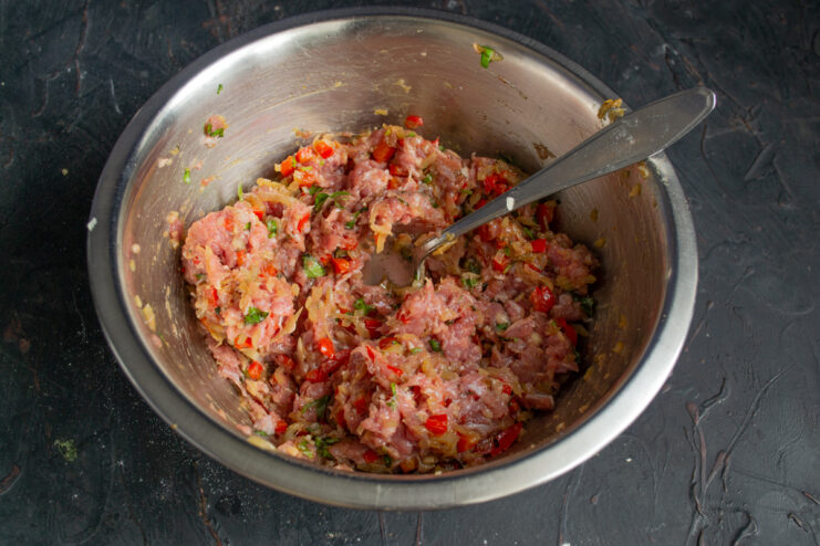 Kneading the filling until uniform Fully mixed and homogeneous dumpling filling resting in a bowl