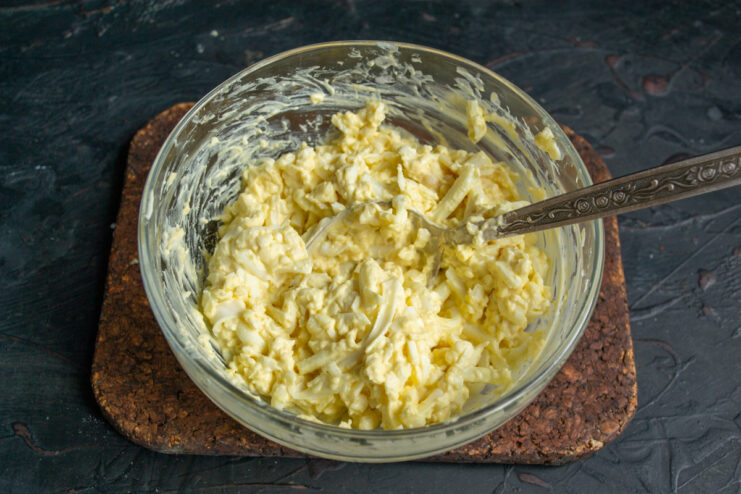A bowl of thoroughly mixed egg and cheese salad filling