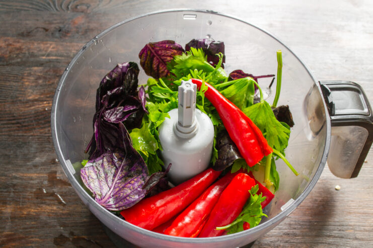 Blending Vegetables And Herbs Adjika ingredients inside a blender bowl before blending