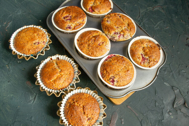 Freshly baked golden muffins sitting inside the metal muffin tin.