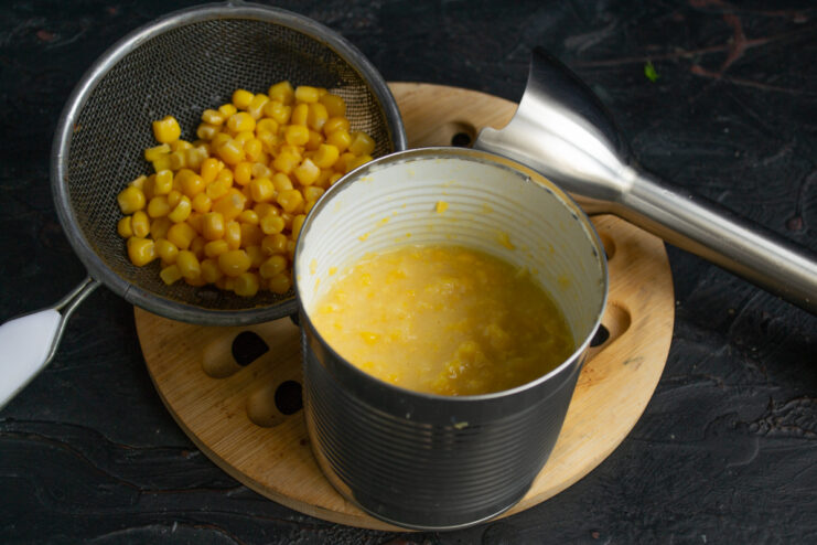 Preparing the Corn Puree Blending corn with an immersion blender in a tall container