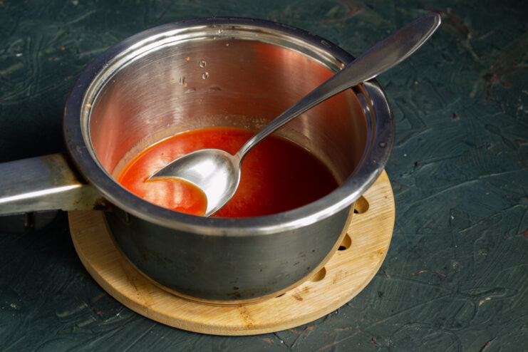 Seasoned tomato juice boiling in a saucepan on the stove