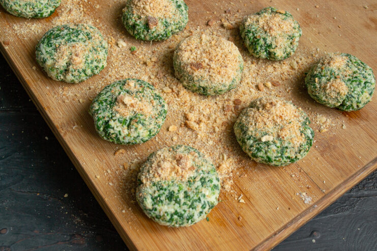 Raw vegetable patties evenly coated in dry breadcrumbs