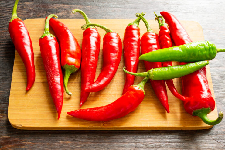 Choosing The Best Chili Peppers Red and green hot chili peppers on a wooden board
