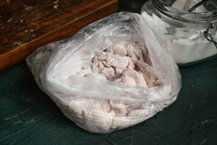 Breading In A Bag Chicken pieces coated in cornstarch inside a plastic bag