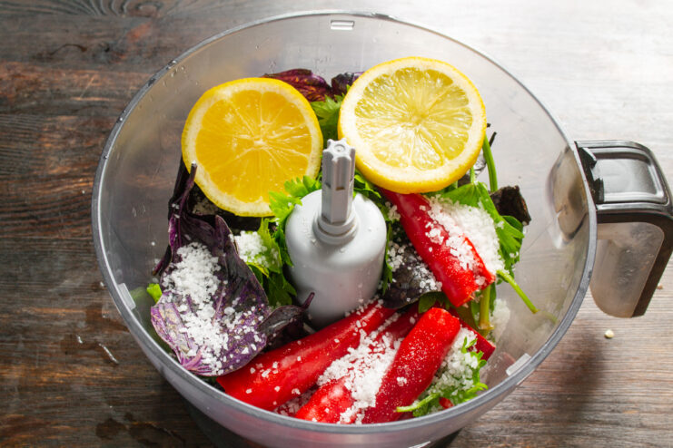 Adding Lemon Juice And Salt Fresh lemon and sea salt added to vegetables in a blender
