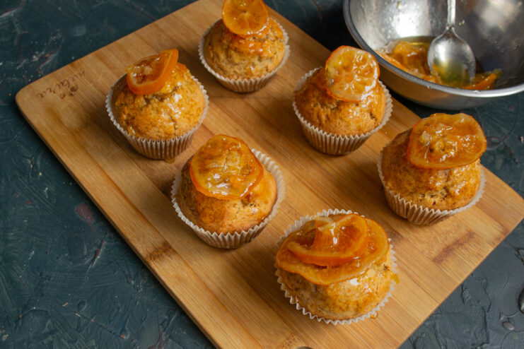 Garnishing The Dessert Stuffed muffins garnished with fresh orange slices on a wooden board