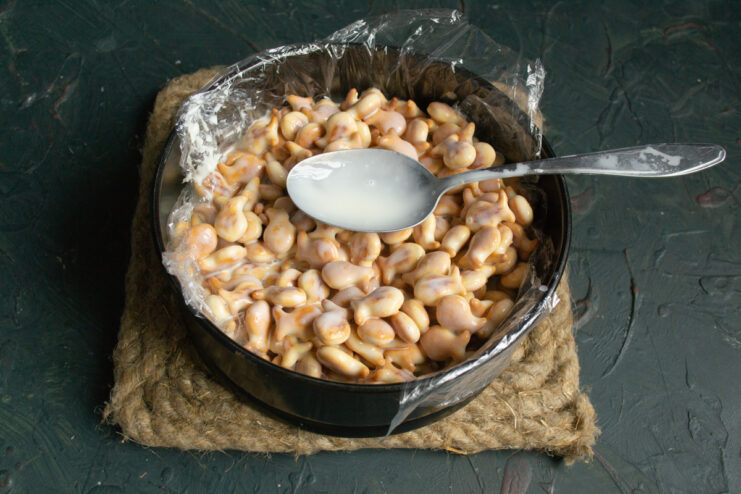Spreading the cake layer Cracker and cream mixture spread evenly inside a plastic-lined springform pan
