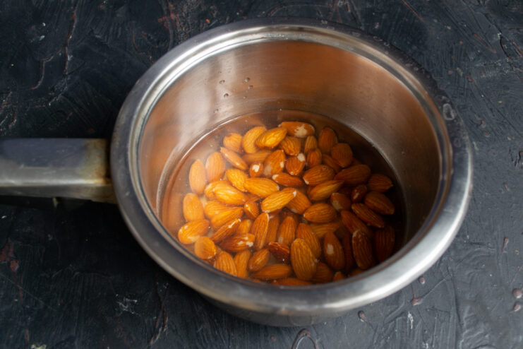 Almonds soaking in boiling water in a saucepan